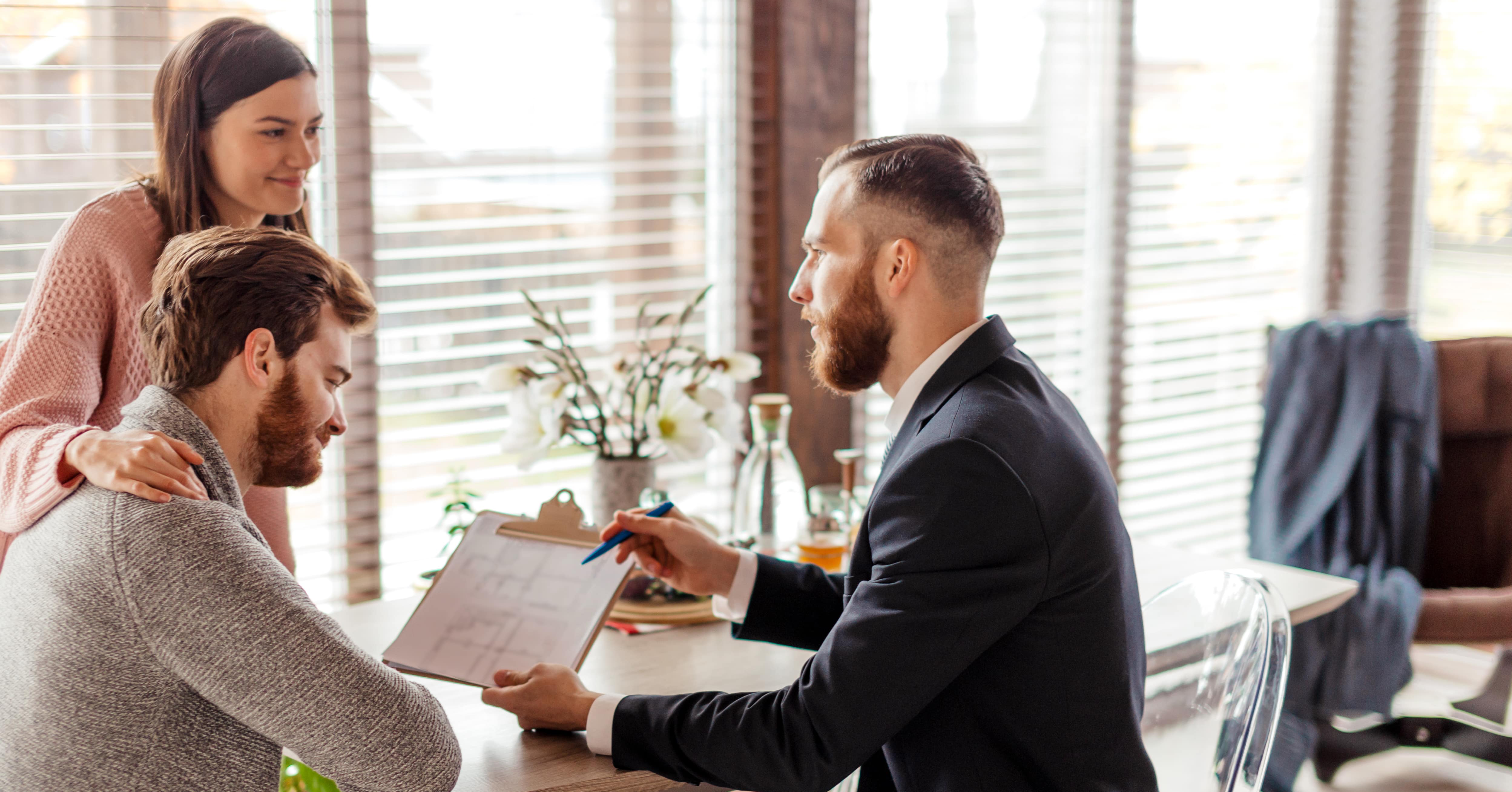 Landlord reviewing paperwork with man and woman